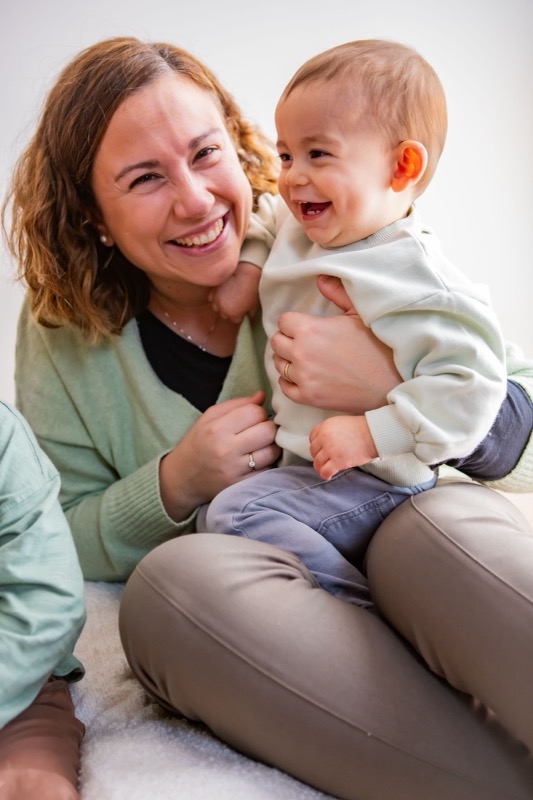 Mama lacht met haar zoontje op schoot