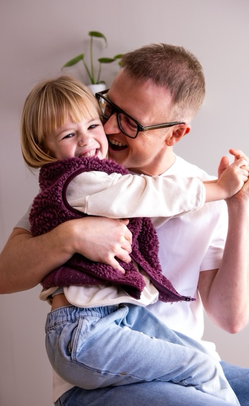 Papa knuffelt zijn lachende dochter