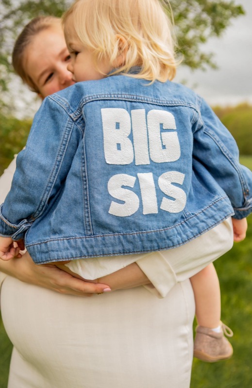 Grote zus met 'Big sis'-jasje bij de zwangere buik