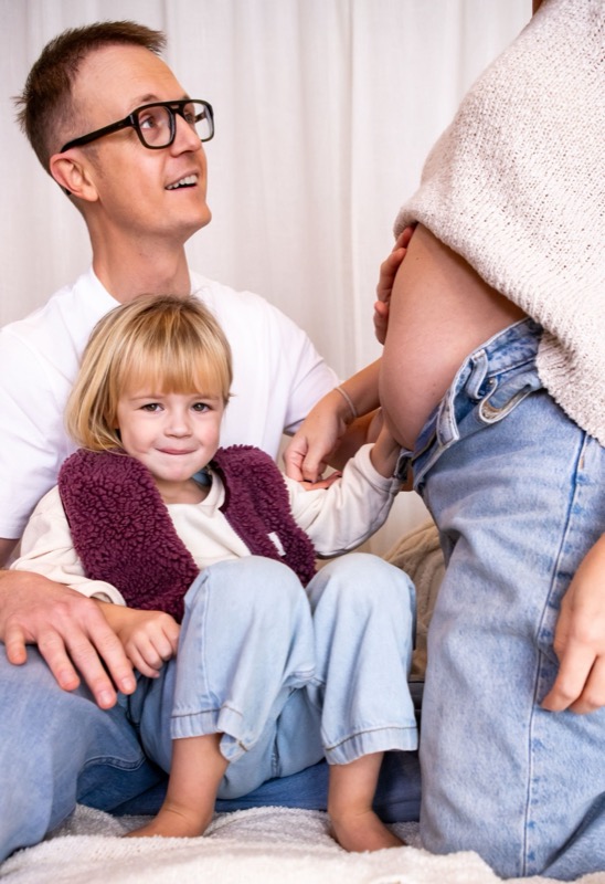 Papa en dochtertje bij de zwangere buik van mama