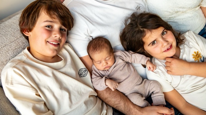 Broer en zus samen met de nieuwe baby