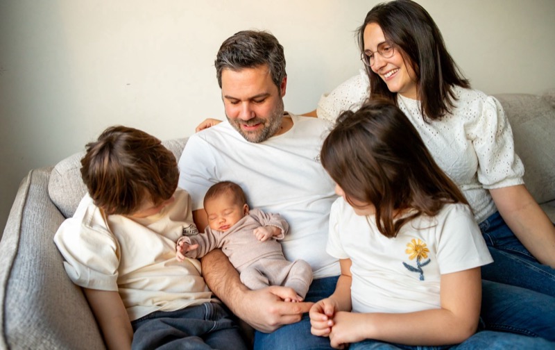 Gezin met de pasgeboren baby samen in de zetel