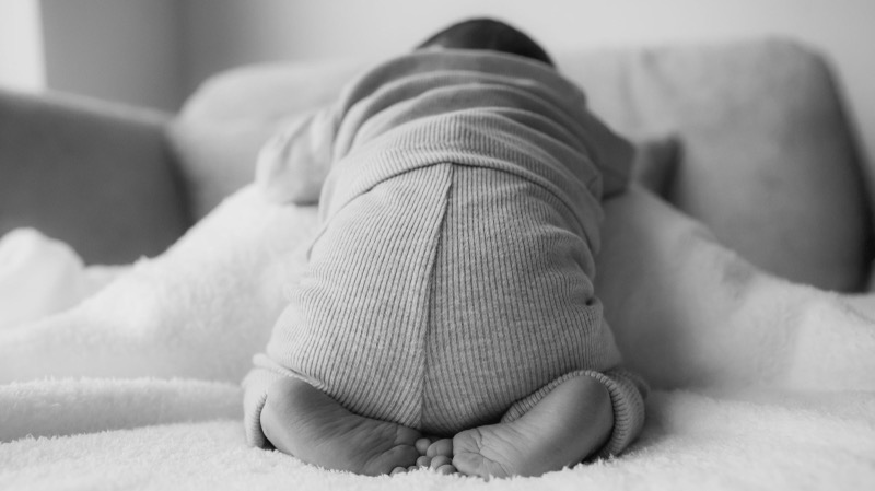 Zwart-witfoto van een slapende baby op het buikje