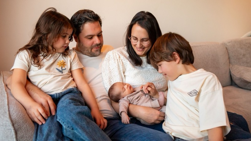 Het hele gezin met de nieuwe baby in de zetel