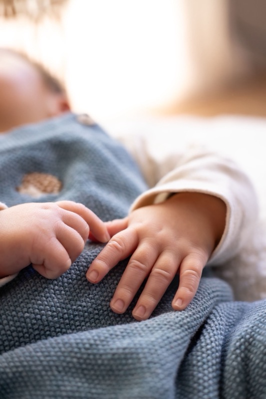 Babyhandje op een blauw dekentje