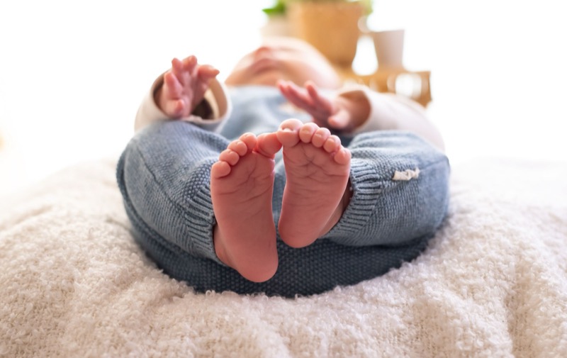 Kleine babyvoetjes op een zacht wit dekentje