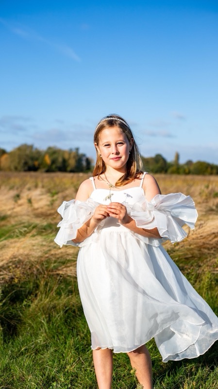 Meisje in een wit kleedje in het veld, buitenportret